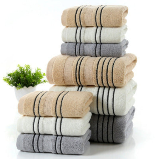 Stack of striped towels in beige, gray, and white on a white background with a small plant.